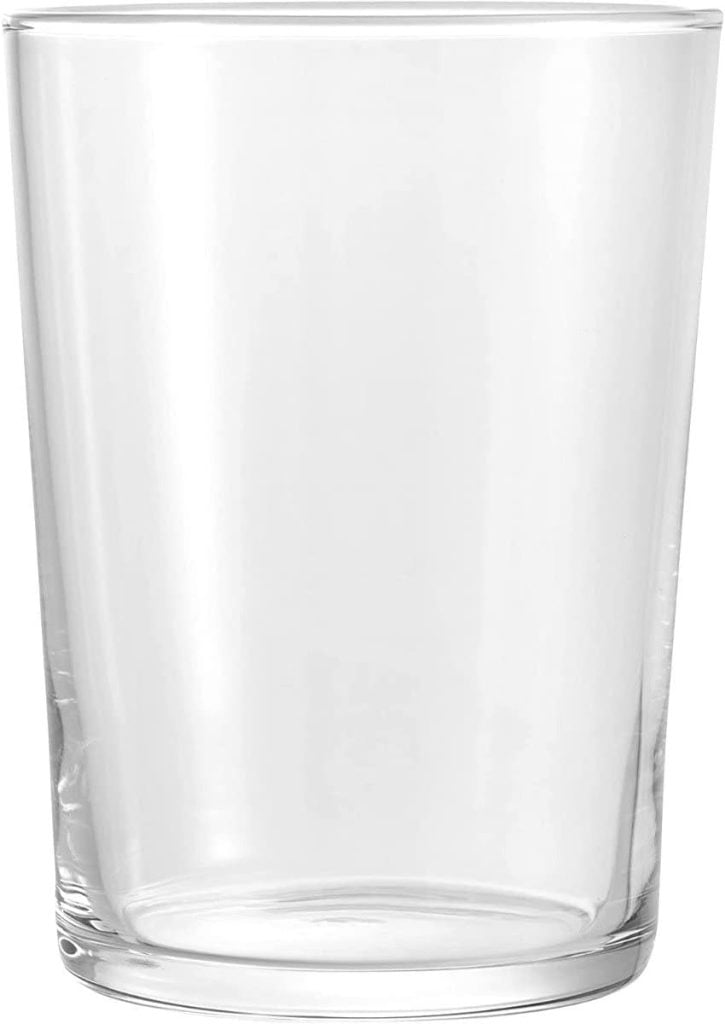 A clear, empty glass cup with a smooth, cylindrical shape sits elegantly against a plain white background, embodying the minimalist charm perfect for open kitchen shelving.