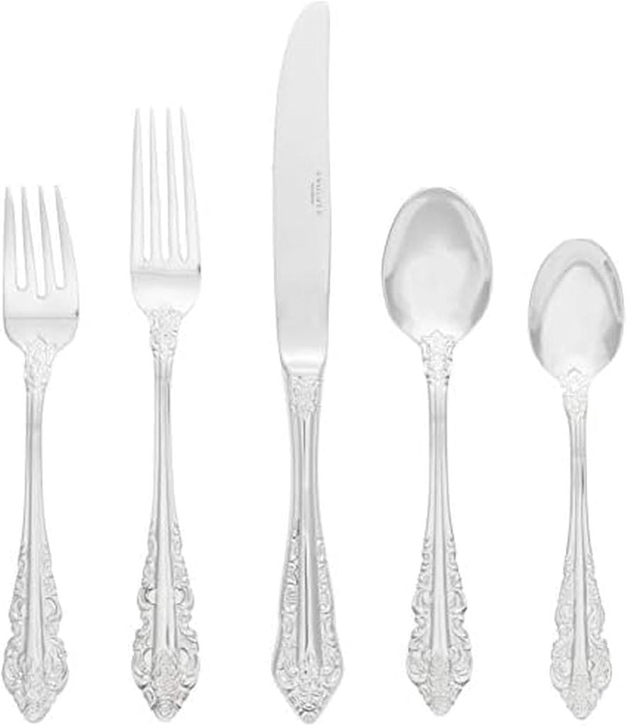 A five-piece silverware set with ornate handles, including two forks, a knife, a tablespoon, and a teaspoon—perfect for enhancing your Valentine table decorations and arranged elegantly side by side.