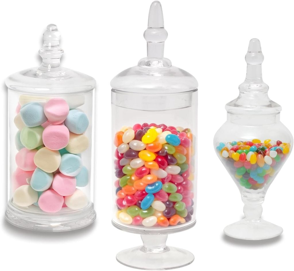 Three glass jars filled with pastel marshmallows, colorful jelly beans, and assorted jelly beans, each with a lid.