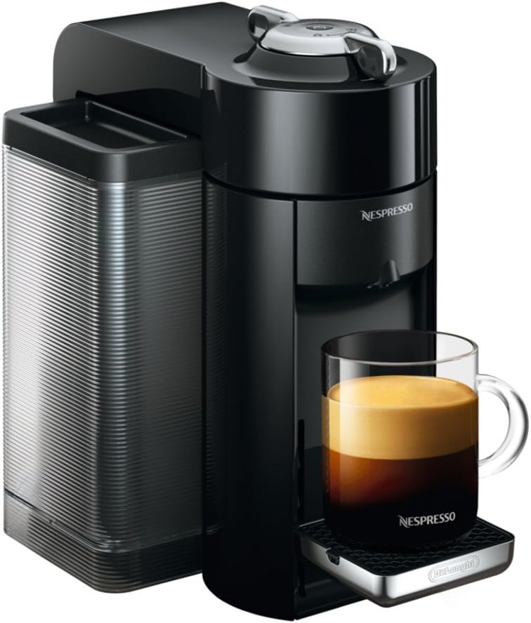 The sleek black Nespresso coffee machine, a must-have among your essential kitchen items, sits elegantly with a glass mug filled with freshly brewed coffee on the drip tray.