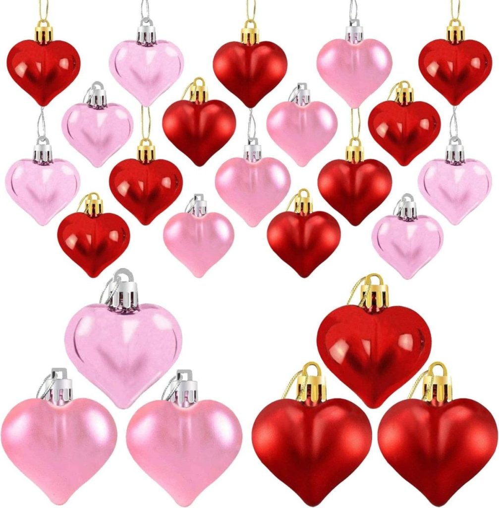Assorted red and pink heart-shaped ornaments with metallic tops, arranged in rows against a white background, evoke the charm of glass apothecary jars filled with colorful treasures.