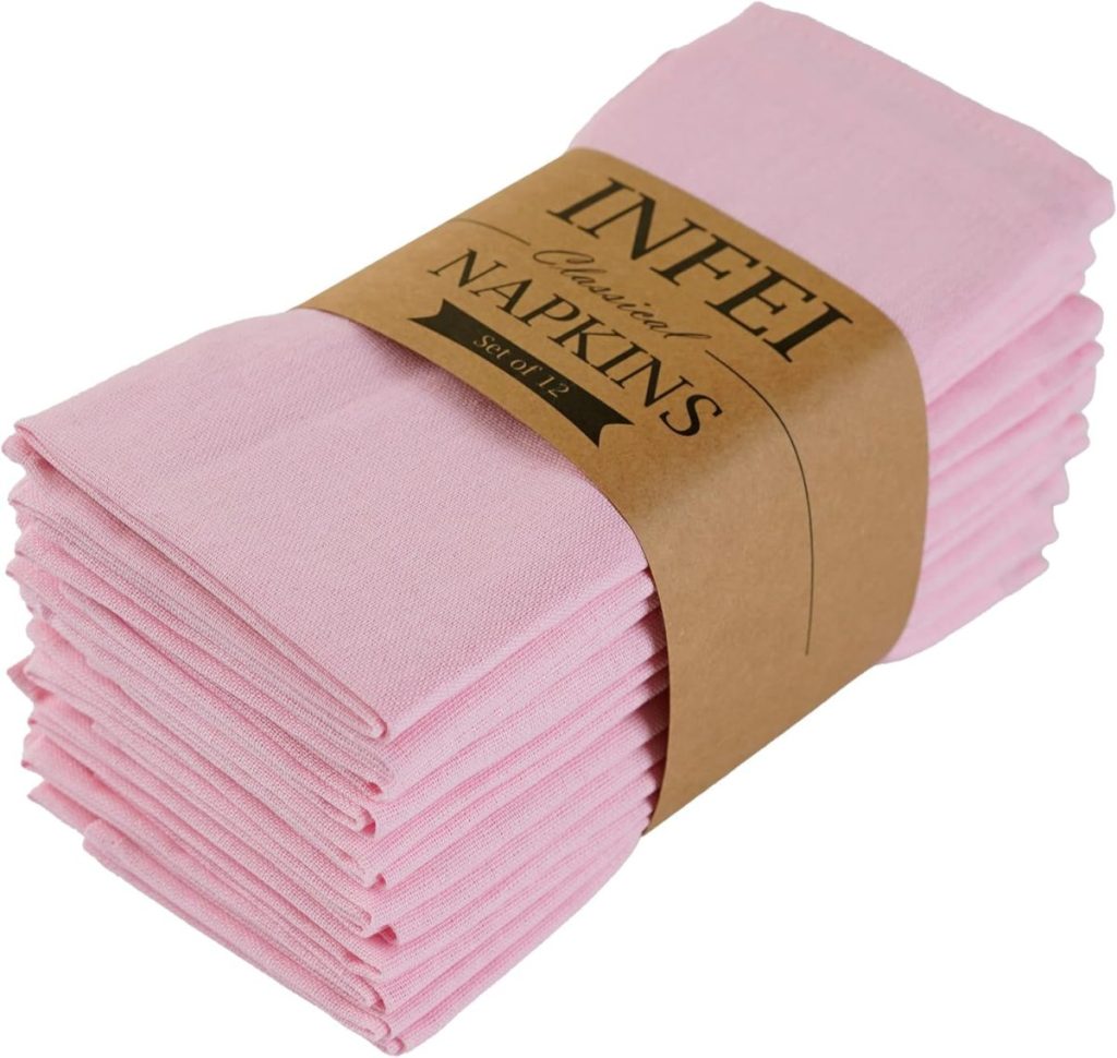 A stack of folded light pink cloth napkins bundled together with a brown paper label that reads "INFEI Classic NAPKINS Set of 12"&mdash;perfect for elegant table settings or inspiring air dry clay ideas for creative decor.