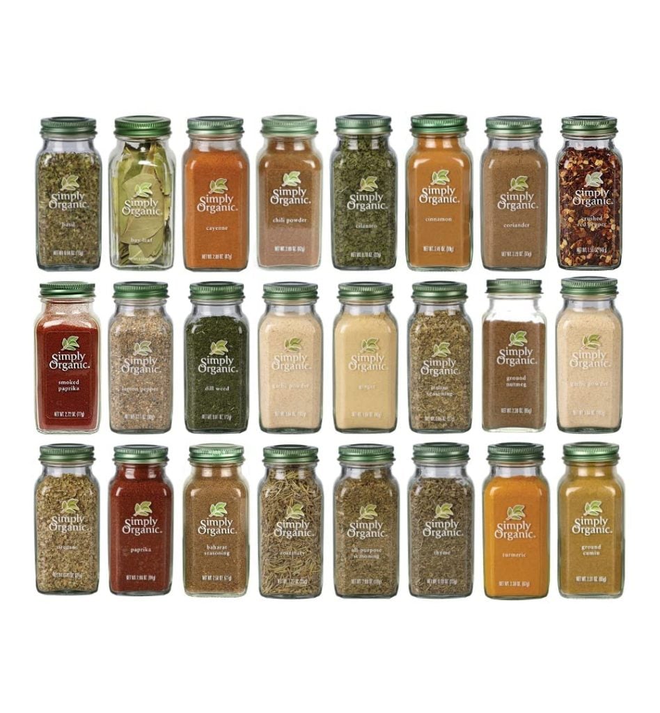 A collection of 24 Simply Organic spice jars, essential kitchen items, arranged in three rows. Each jar is filled with different herbs and spices.