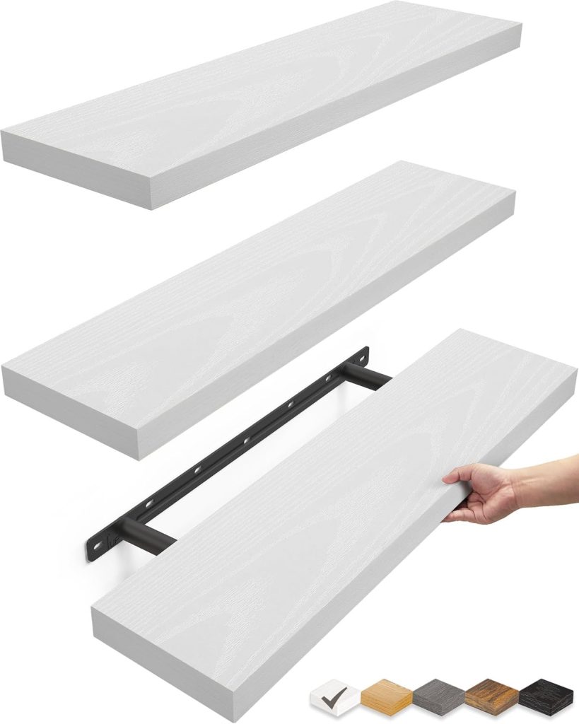 Three white floating shelves, perfect for open kitchen shelving, with one shelf shown being mounted on a black wall bracket; a hand holds one shelf and color options are displayed in the bottom right corner.