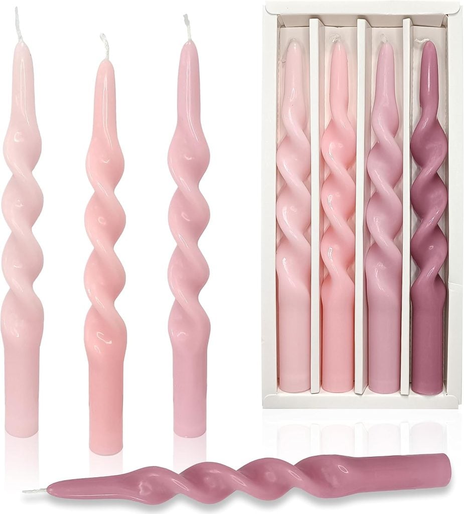 A set of six twisted taper candles in shades of pink, displayed both upright and in a box.