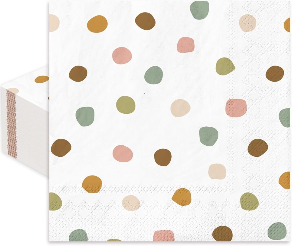 A stack of white paper napkins with a pattern of multicolored polka dots in shades of green, brown, pink, and orange.