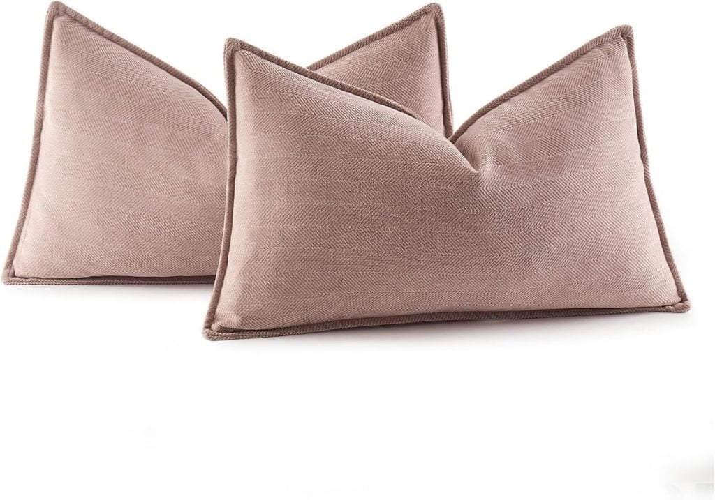 Two rectangular, brown throw pillows with visible seams and a textured fabric are placed upright against each other.