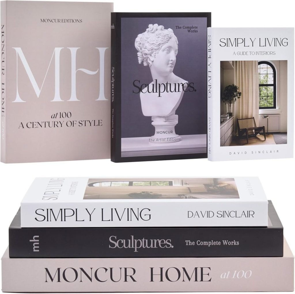 Stack of books with titles including "MH at 100," "Simply Living," and "Sculptures," featuring covers with minimalist design and art images.