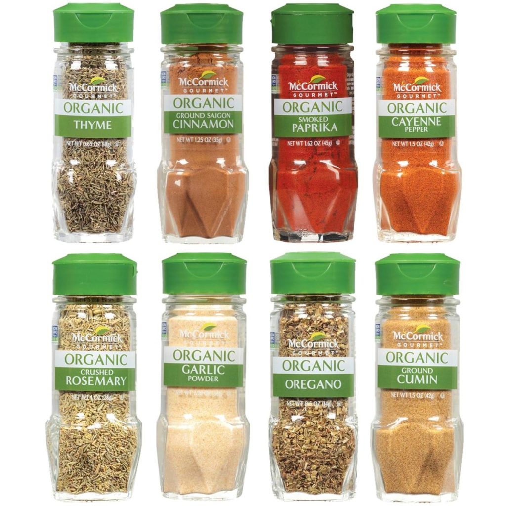 Eight McCormick organic spice jars—kitchen items like thyme, cinnamon, paprika, cayenne pepper, rosemary, garlic powder, oregano, and cumin—are neatly arranged in two rows of four.