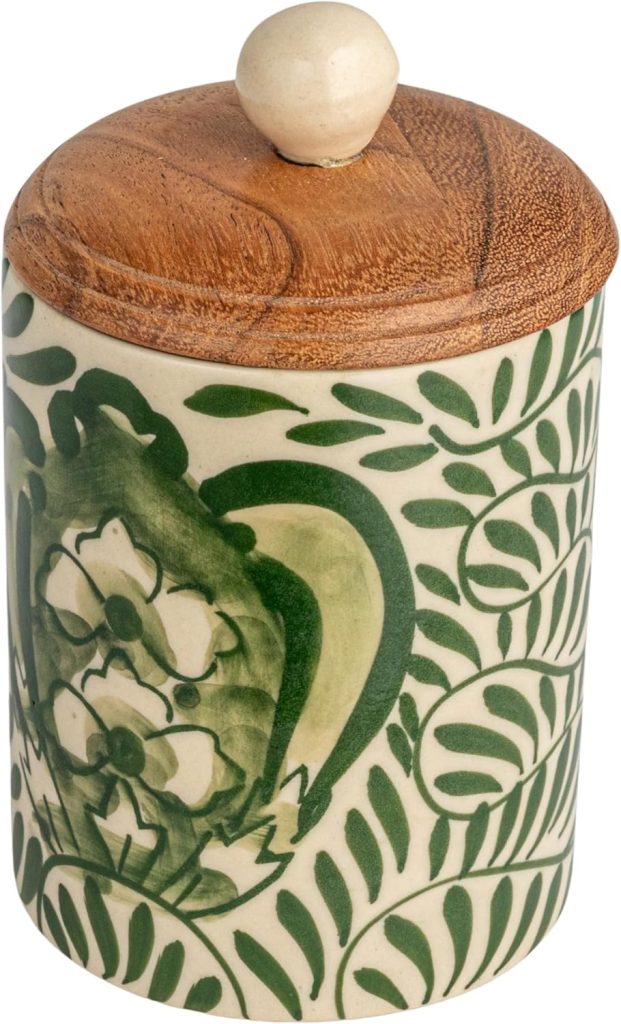 A ceramic container with a green floral and leaf pattern in a winter color palette, topped with a wooden lid and round knob.