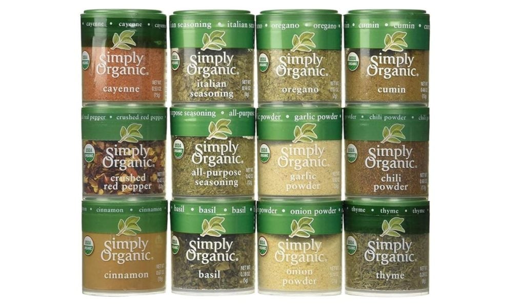 Twelve cans of Simply Organic spices—essential kitchen items—including cayenne, oregano, cumin, crushed red pepper, chili powder, cinnamon, basil, onion powder, garlic powder, Italian seasoning, and thyme.