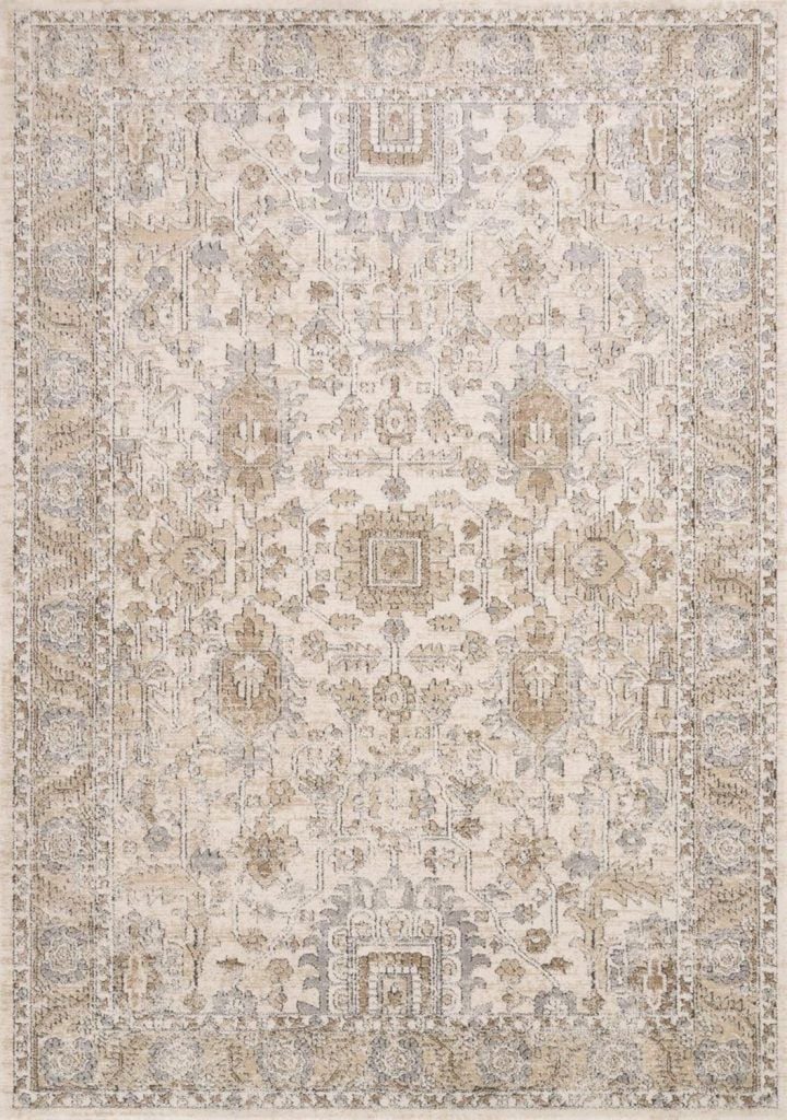 A beige and taupe patterned area rug with intricate floral and geometric designs.