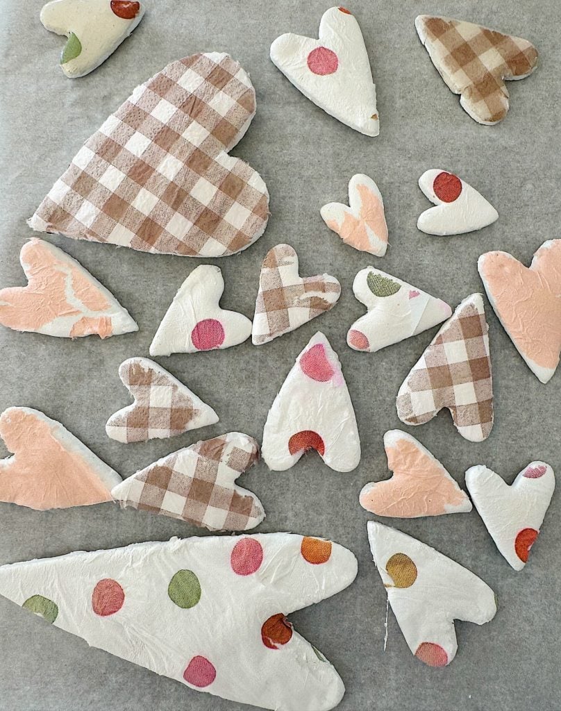 Various heart-shaped cutouts with polka dot and plaid patterns on a light background.