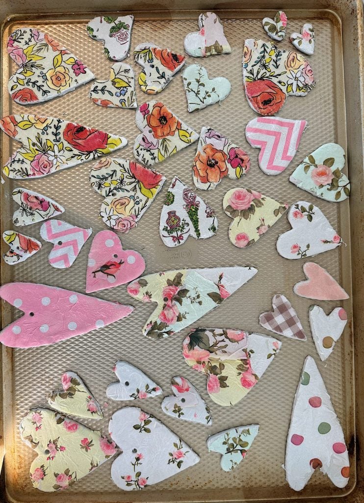 A tray with various floral and patterned paper cutouts in the shapes of hearts and birds.