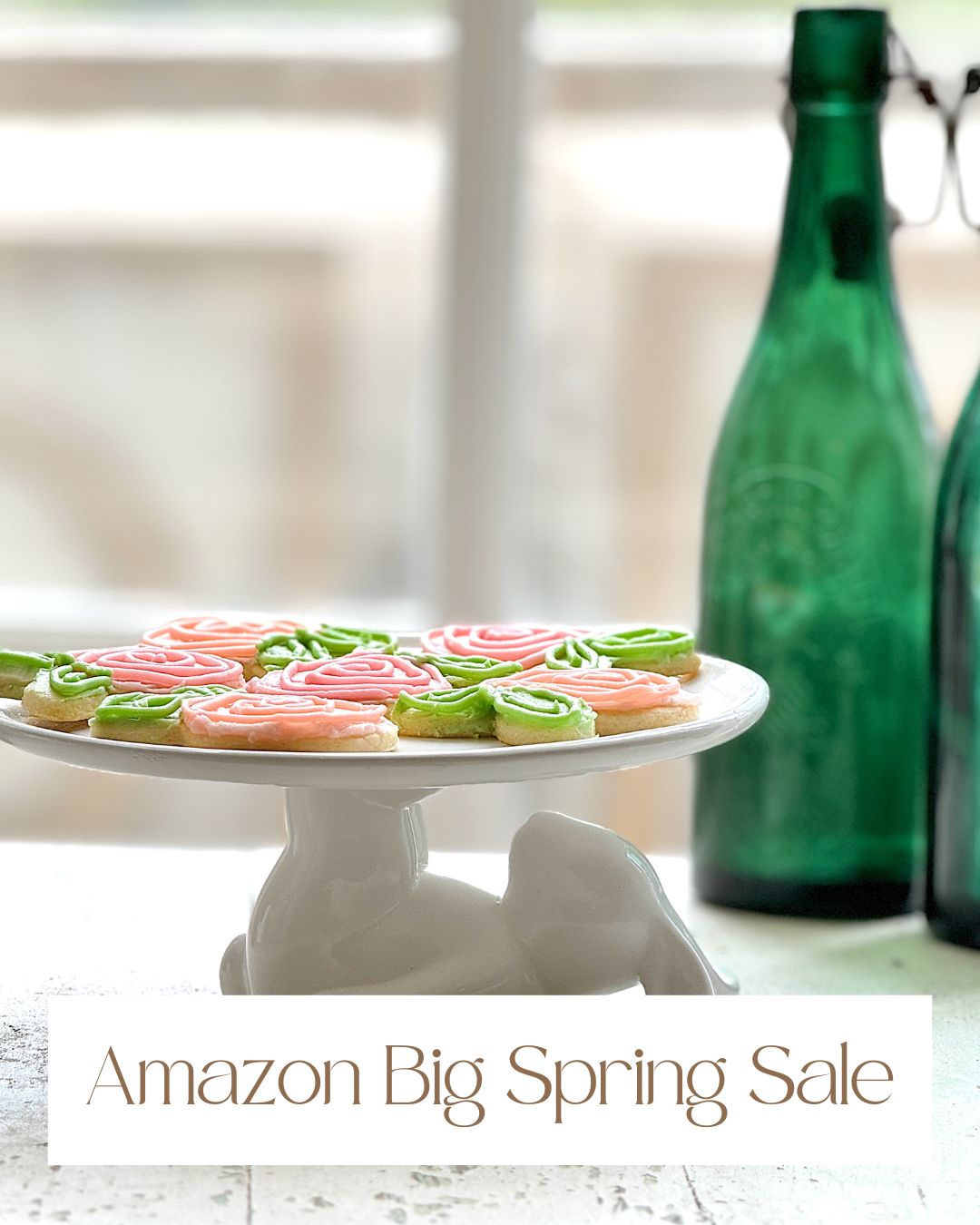 Cookies with pink and green swirled frosting sit on a white rabbit-shaped stand, while two green bottles linger in the background. Text proudly announces the "Amazon Prime Big Spring Sale.