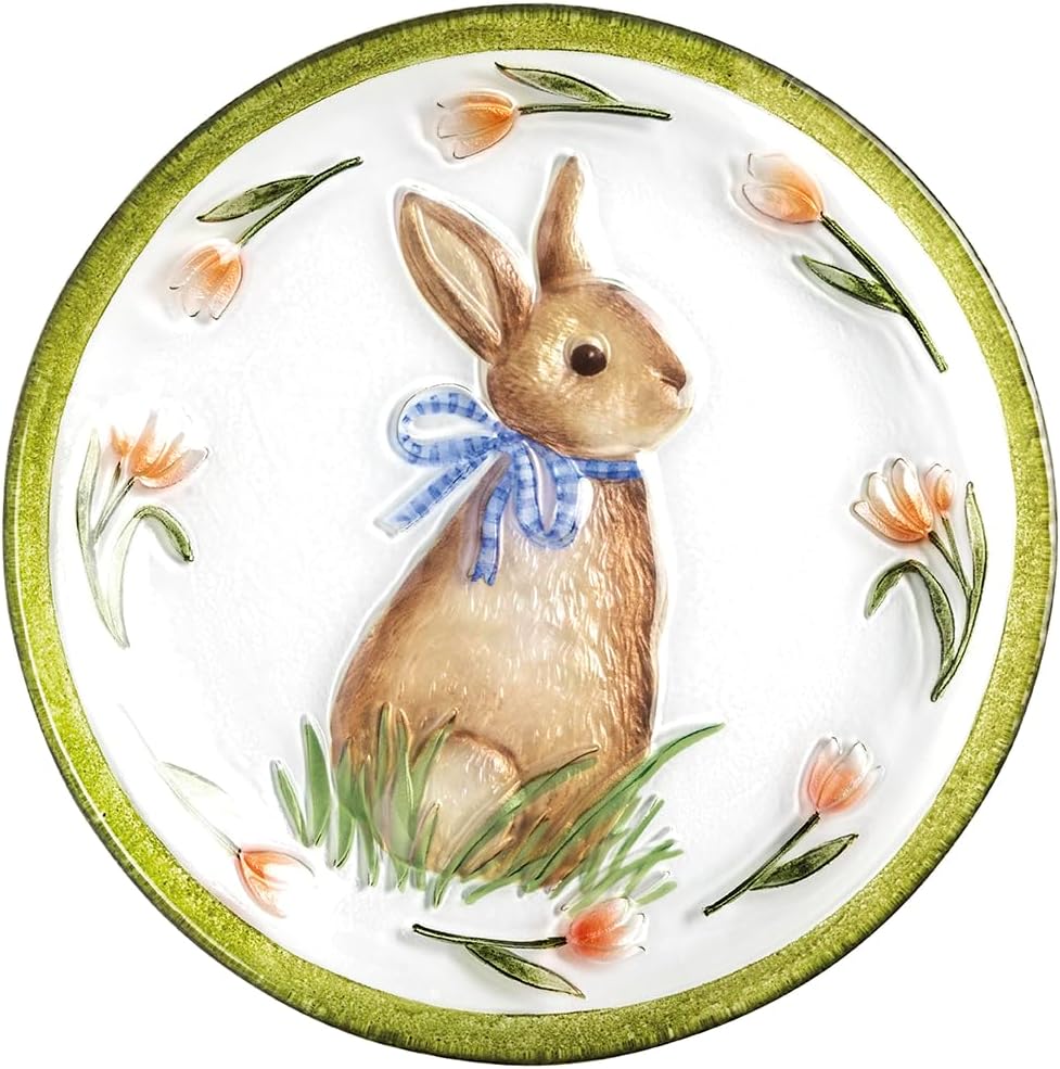 A decorative plate featuring a brown rabbit with a blue ribbon sitting on grass, surrounded by orange flowers and charming flower cookies along the green rim.