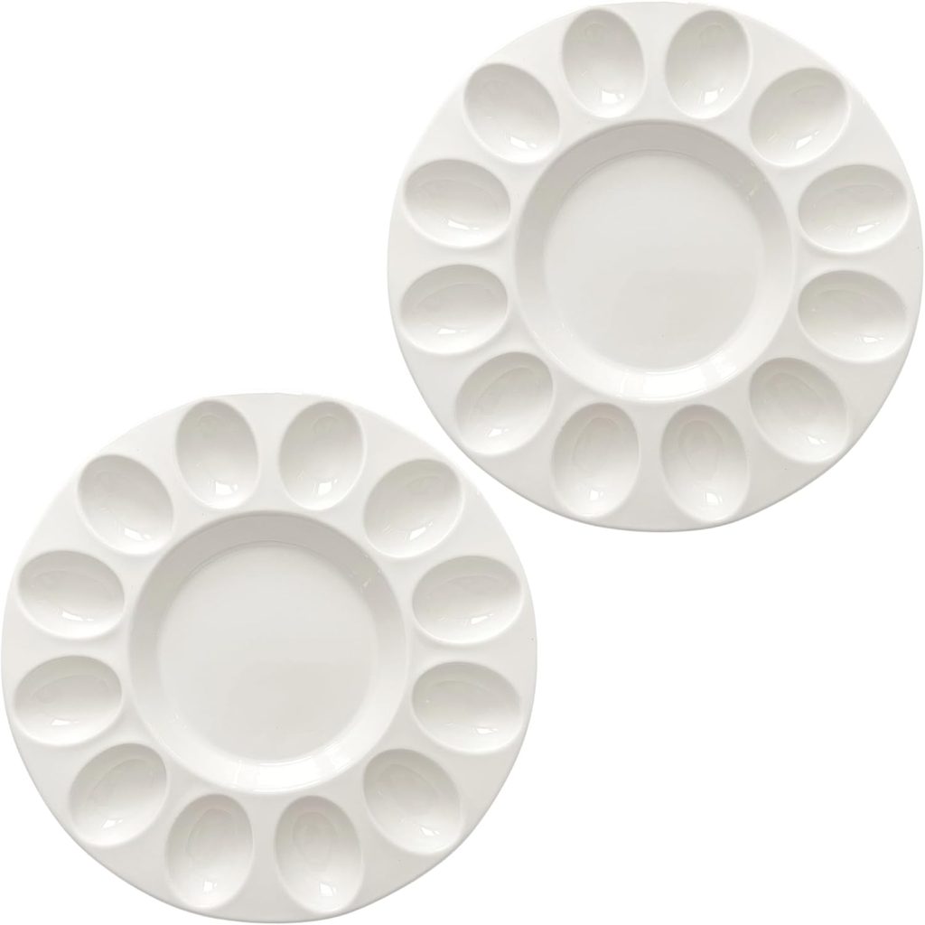 Two round white plastic paint palettes, each with ten outer wells and a large central well, are placed side by side on a white background, resembling the arrangement of plastic Easter eggs ready for decorating.