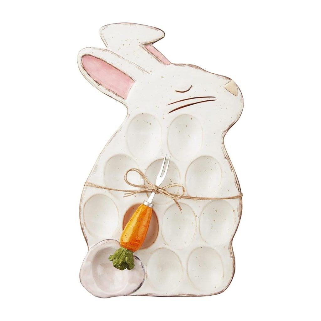 Ceramic egg tray shaped like a bunny, perfect for serving your Best Deviled Eggs Recipe. Features twelve egg slots, a twine bow, a carrot-shaped fork, and pink accents on the ears.