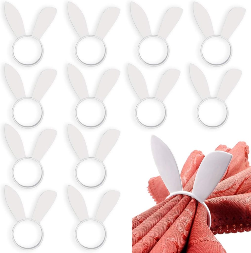 Twelve white napkin rings shaped like bunny ears, perfect for Easter decor, with one shown holding a folded pink napkin.
