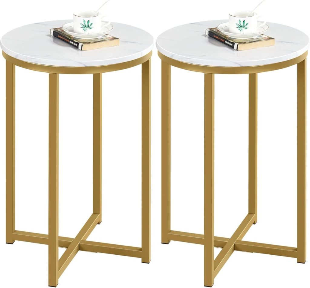 Two round side tables with gold metal frames and white tops offer a touch of vintage decor, each holding a cup, saucer, and a book.