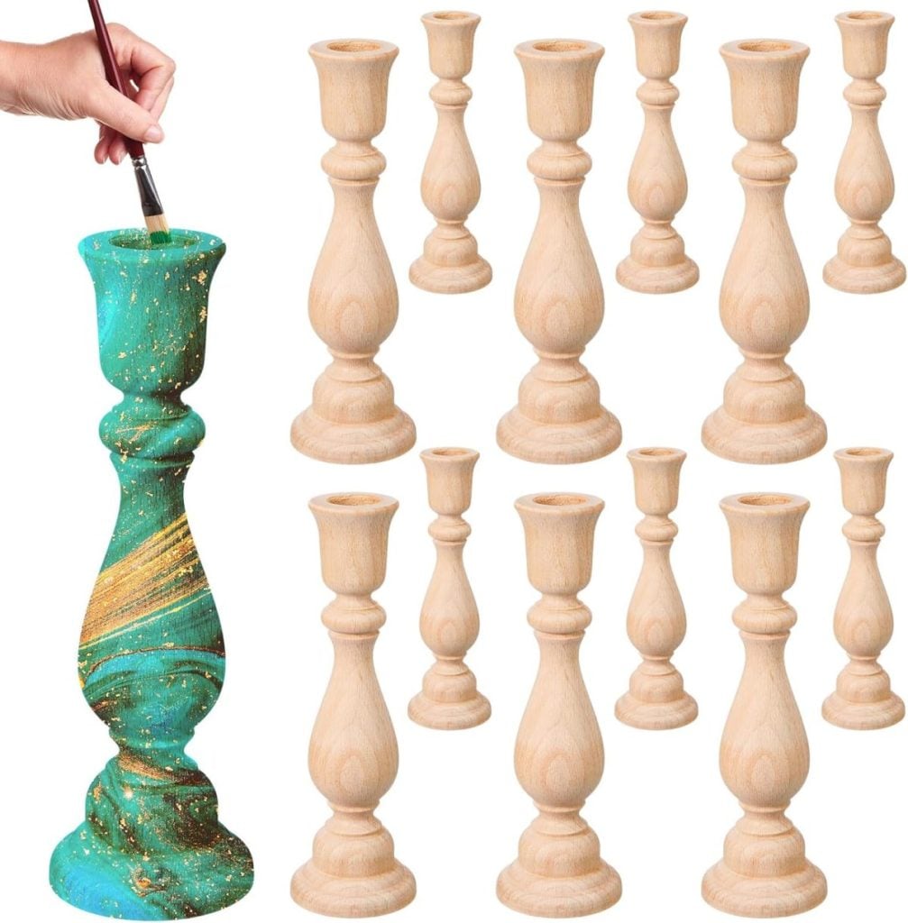A hand paints a wooden candlestick green and gold—perfect for spring decor; eleven unfinished wooden candlesticks are displayed to the right.