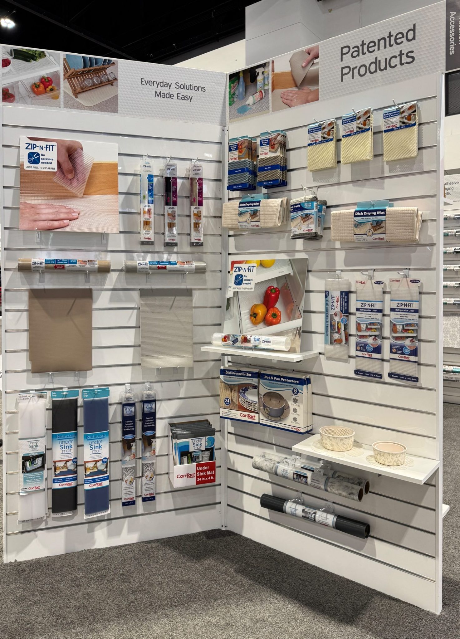 Store display featuring various kitchen and household products, including countertop covers, protective mats, and storage solutions, on white slatwall panels.