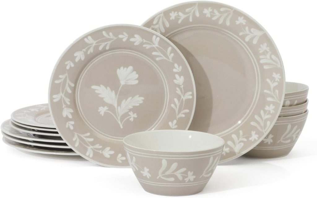 A set of beige ceramic plates and bowls with white floral patterns, arranged in stacked and standing positions—perfect for serving Easter eggs at your spring gatherings.