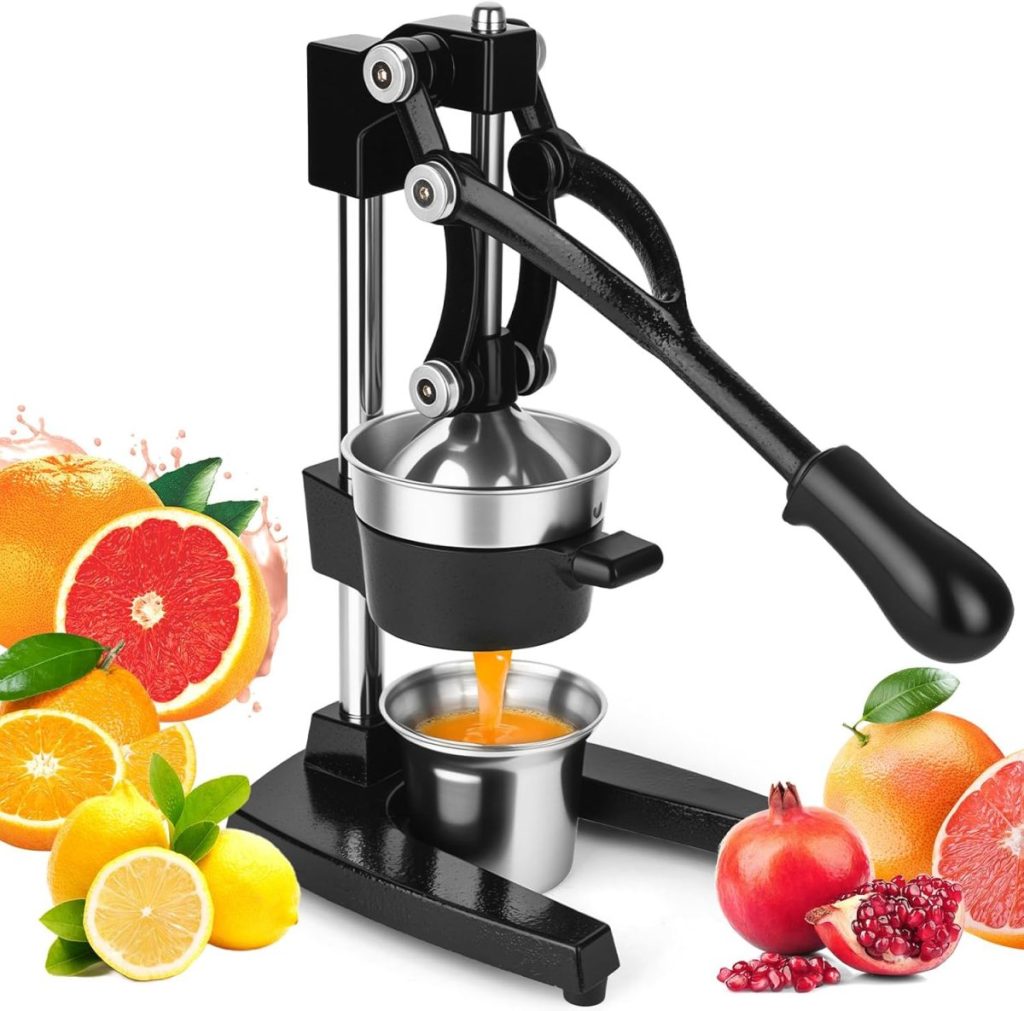 A manual citrus juicer with a lever is squeezing juice into a metal cup, surrounded by assorted fruits&mdash;like oranges, lemons, grapefruits, pomegranates&mdash;and a tempting blueberry galette.
