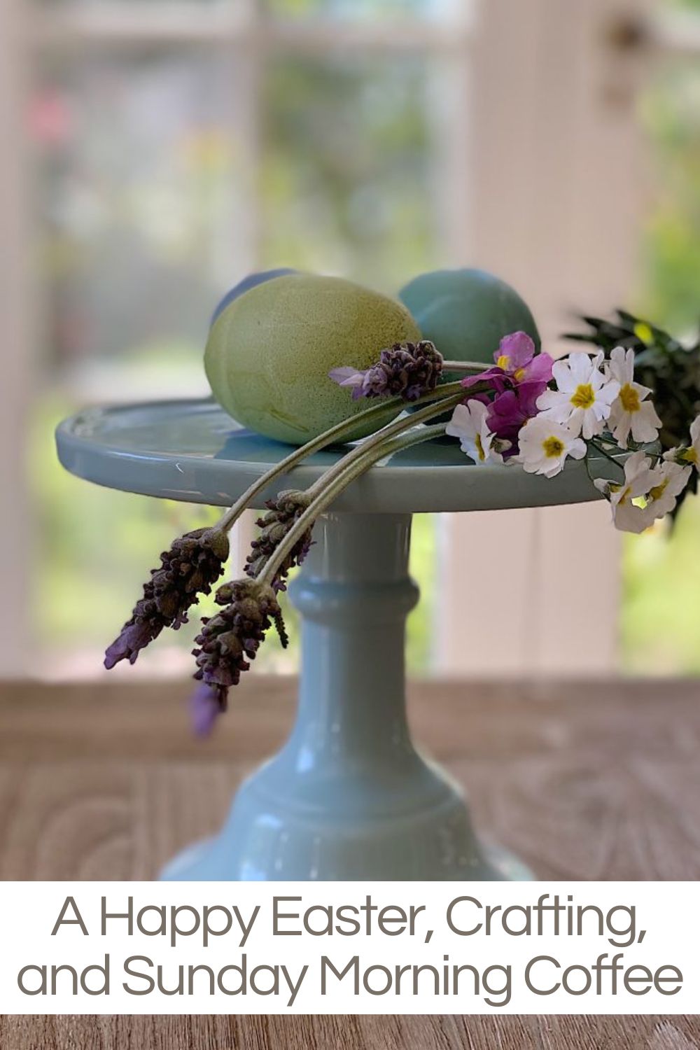 A pastel cake stand holds two decorative eggs and a small bouquet of flowers. Text below reads: "A Happy Easter, Crafting, and Sunday Morning Coffee.