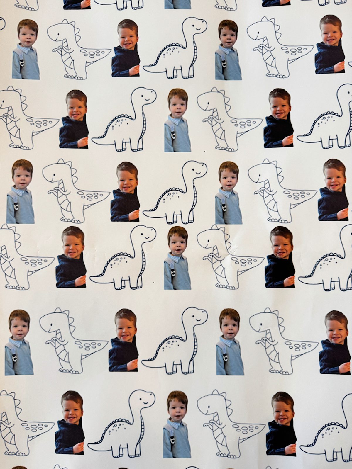 Patterned wallpaper with alternating photos of a child in a blue shirt and outline drawings of dinosaurs.