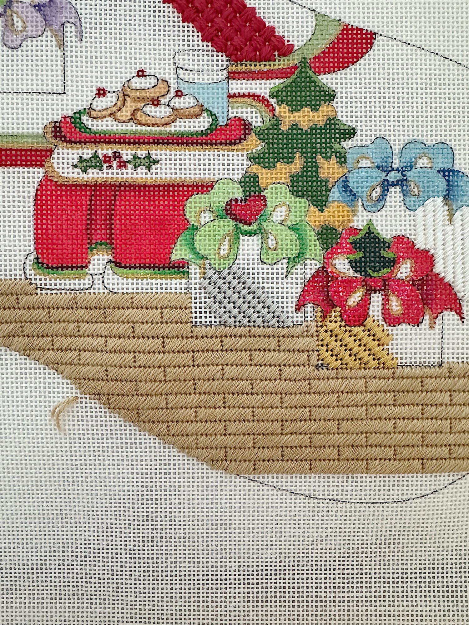 Needlepoint design featuring a festive scene with cakes on a red table, colored bows, and holiday greenery.