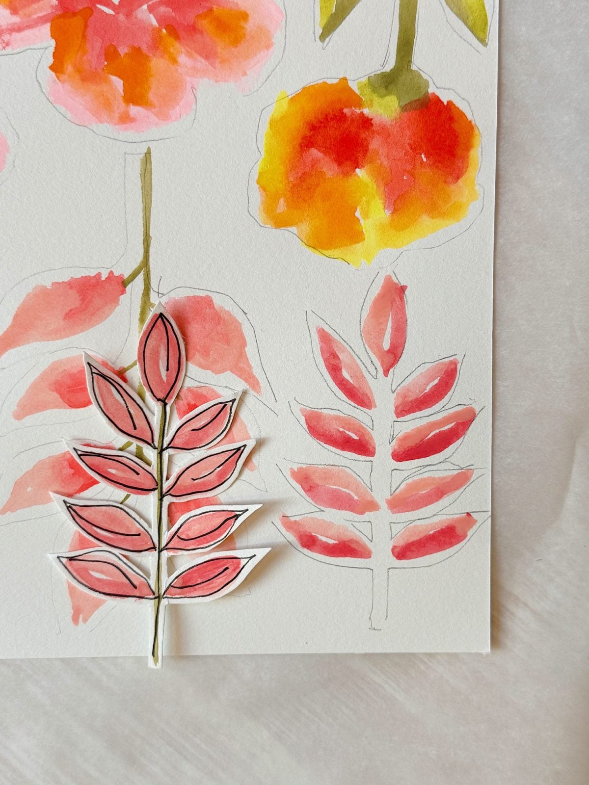 A watercolor painting of red and yellow flowers with red leaves, one leaf illustration is cut out and placed over the painted outline.