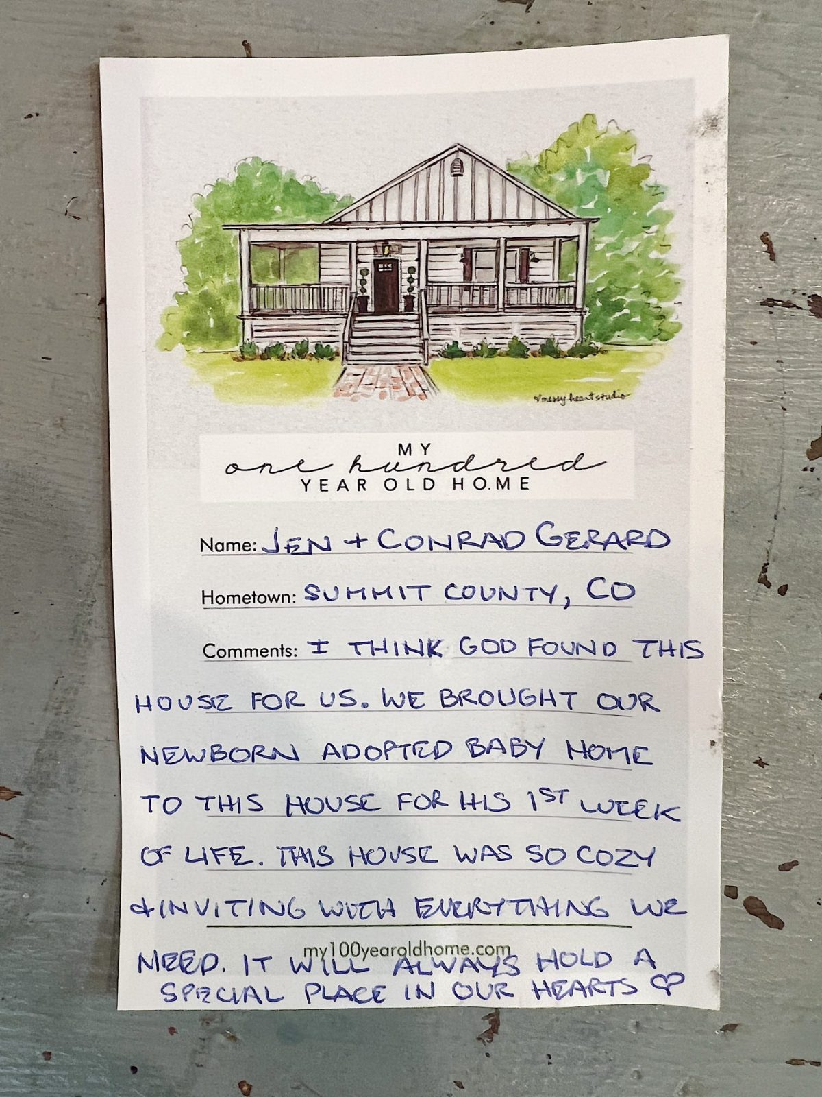 Handwritten note on a placard with an illustration of a house. Note details personal experience of adopting a baby and staying in a cozy, inviting home. Includes a heart symbol at the end.