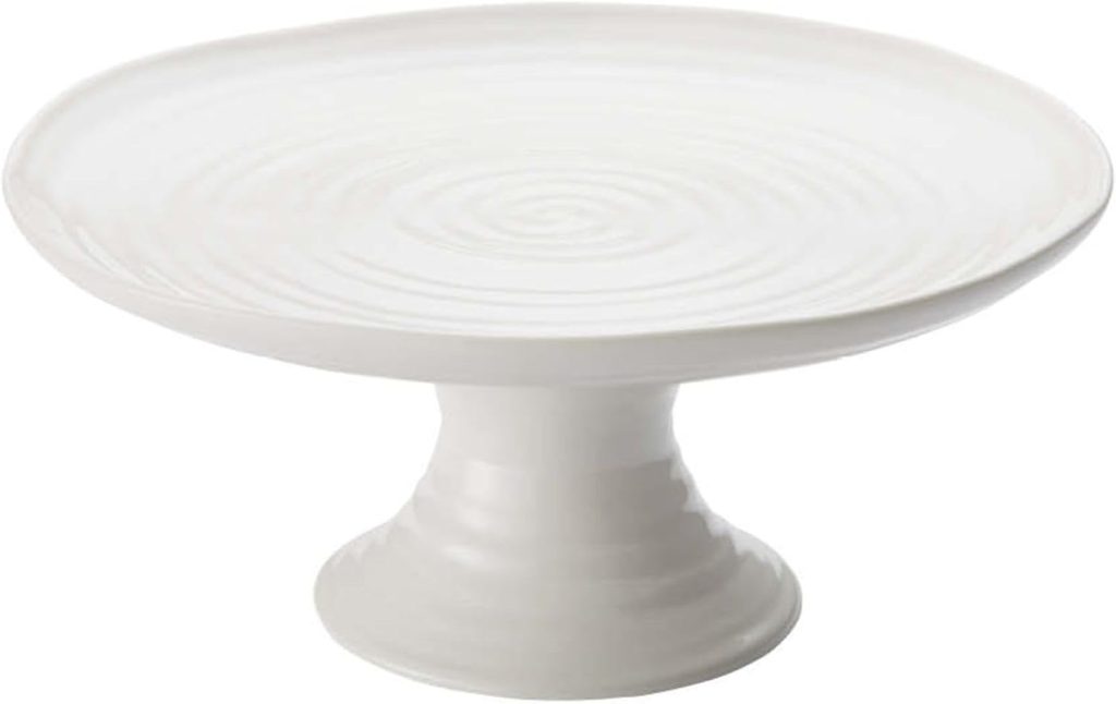 A plain white ceramic cake stand with a wide, round top and a sturdy pedestal base—perfect for showcasing your favorite spring cake.