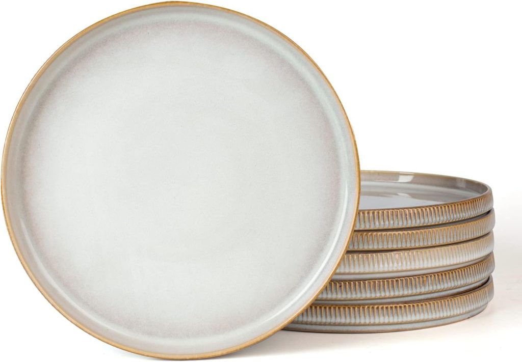 A stack of six round, light gray ceramic plates with a subtle brown rim, displayed with one plate standing upright in front—perfect for showcasing your favorite salad bar ideas.