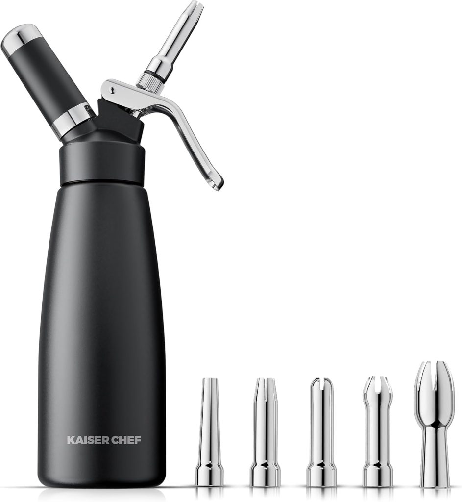 A black whipped cream dispenser labeled "Kaiser Chef" with a metal lever, perfect for topping your favorite mud pie, and five interchangeable stainless steel nozzles displayed in front.