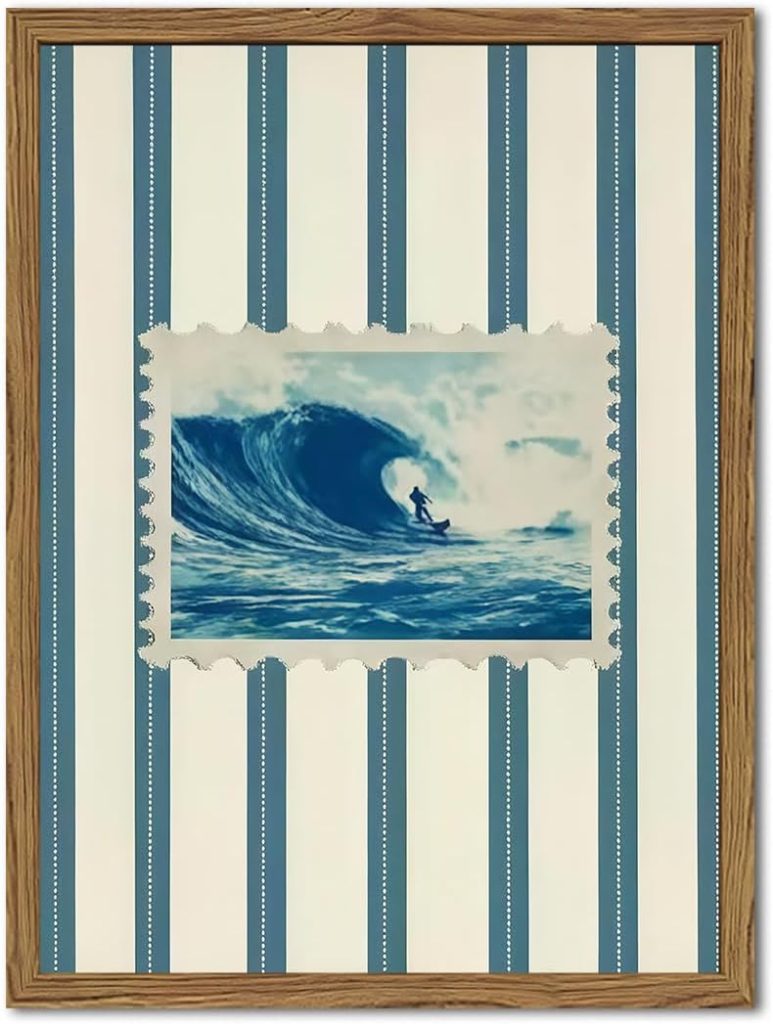 A framed picture shows a surfer riding a large ocean wave, set against a blue and white vertical striped background—perfect for those seeking fresh summer decorating ideas.