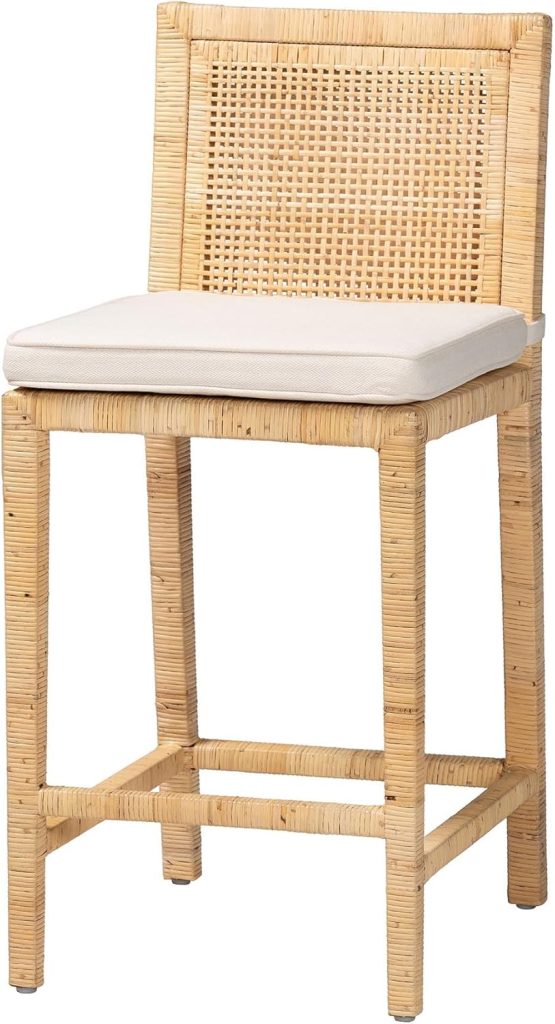 A wicker bar stool perfect for a farmhouse kitchen, featuring a woven backrest, light-colored padded seat cushion, and straight legs with convenient footrests.