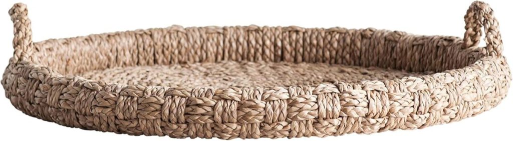 Round woven wicker basket tray with raised edges and two handles, perfect for summer decorating ideas, displayed on a white background.