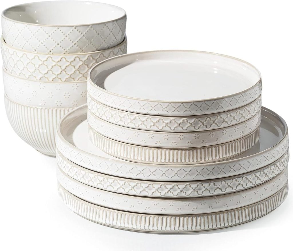 A set of patterned white ceramic dishes, including four bowls and eight plates, arranged in two stacks—perfect for displaying in your open concept kitchen.