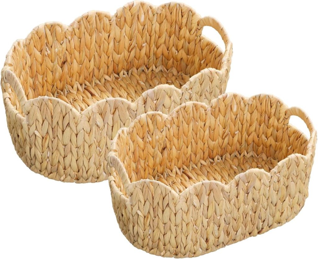 Two woven oval baskets with handles, made from natural straw or seagrass, placed side by side—perfect for summer decorating ideas.
