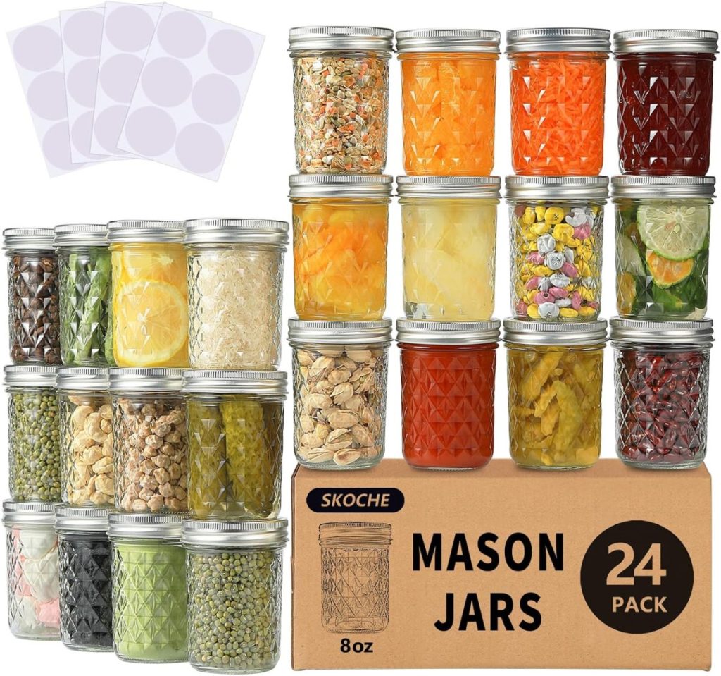 A set of 24 glass mason jars filled with various foods, including a delicious mixed berry assortment, accompanied by blank labels and a box labeled "SKOCHE Mason Jars 8oz 24 Pack".