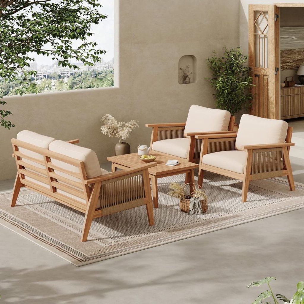 Outdoor patio set with wooden chairs, a loveseat, and coffee table on a patterned rug in a shaded terrace area, featuring neutral outdoor cushions and decorative items.
