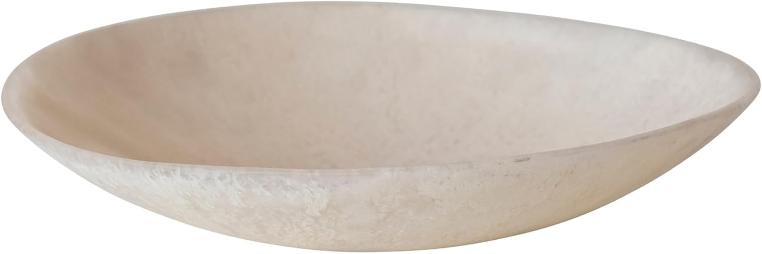 A shallow, round, light beige stone bowl with a smooth matte finish, reminiscent of summer at the beach, photographed against a white background.