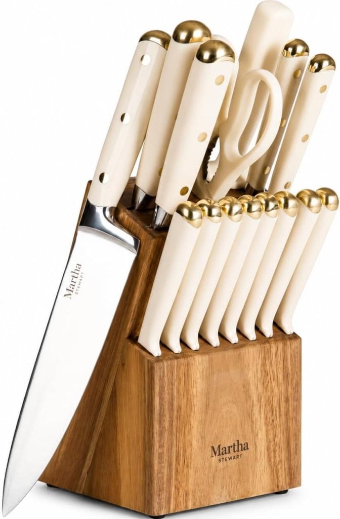 A wooden knife block holds a set of cream and gold-handled knives, kitchen shears, and a sharpening rod labeled with the Martha Stewart brand&mdash;perfect tools for preparing healthy summer recipes.