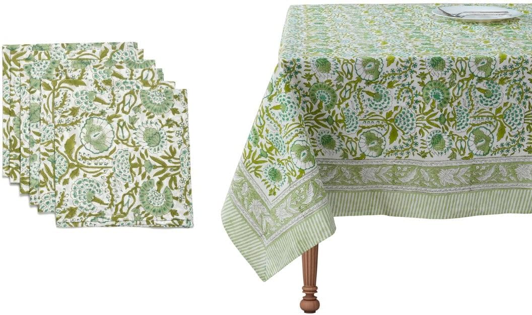 A green and white floral-patterned tablecloth on a table, with matching folded napkins beside it&mdash;perfect for adding charm to any dinner party.