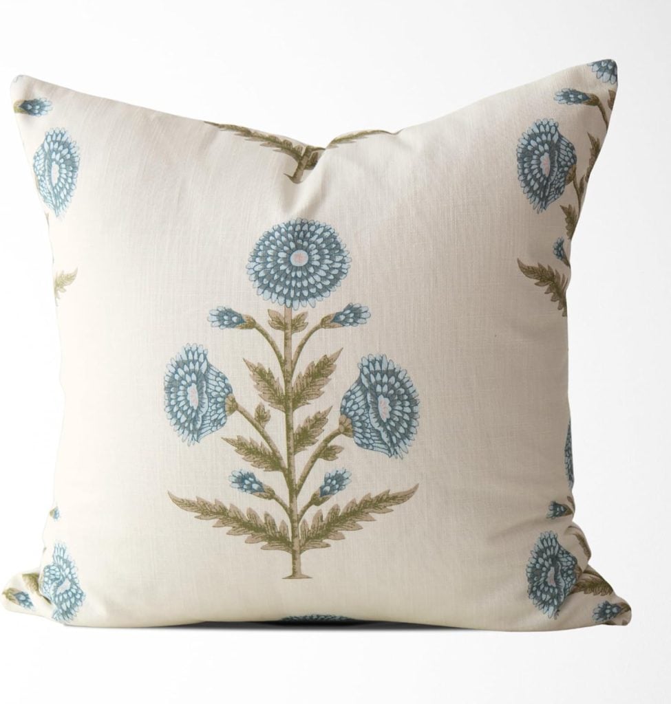 Square white throw pillow with a pattern of blue floral designs and green stems on the front, perfect for interior designers seeking a touch of elegance and charm in their decor projects.