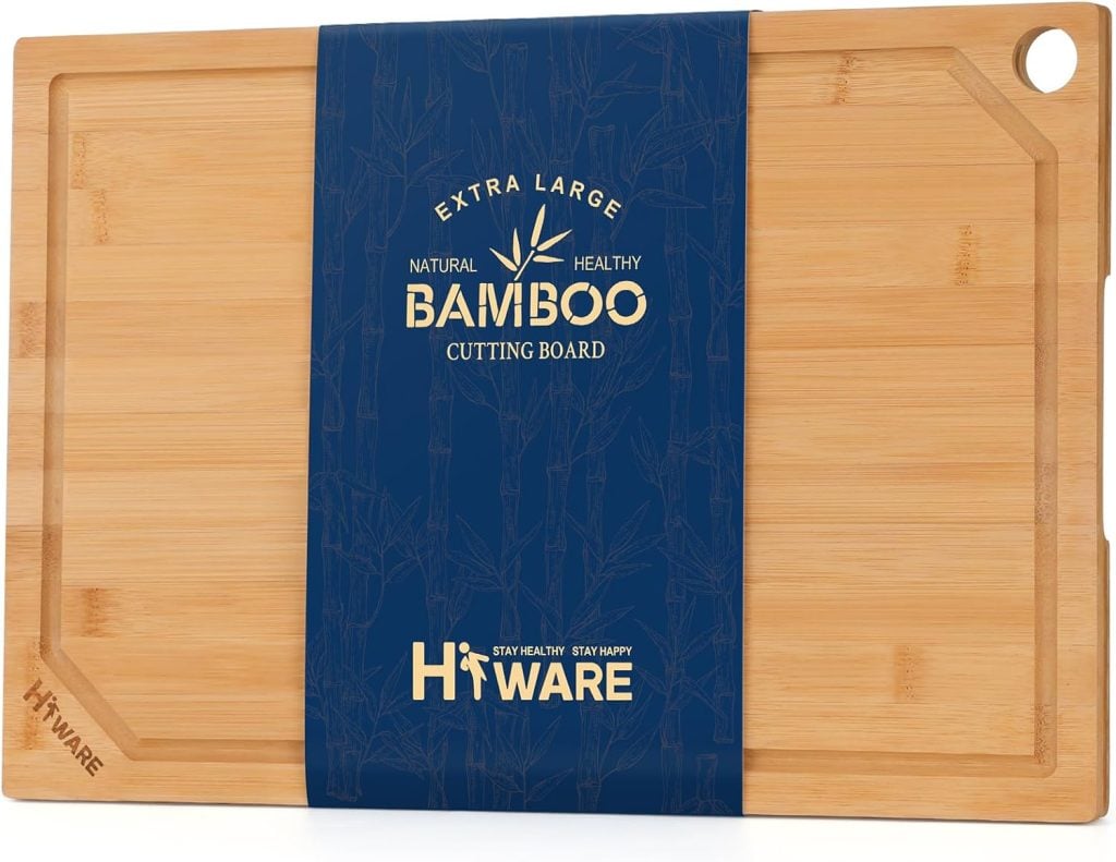 An extra large rectangular bamboo cutting board with a juice groove, corner hole, and blue Hiware branded packaging around the center&mdash;perfect for prepping healthy summer recipes.