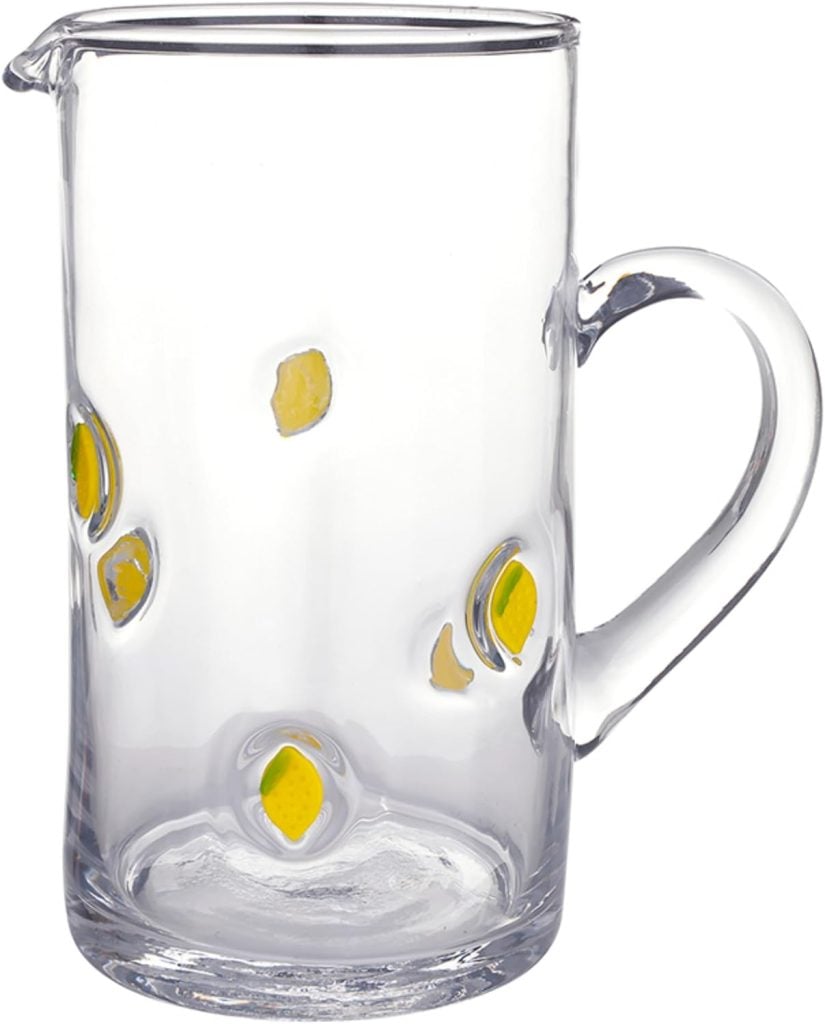 Clear glass pitcher with a handle, featuring vibrant lemon decor in yellow oval patterns and a small pouring spout at the top.