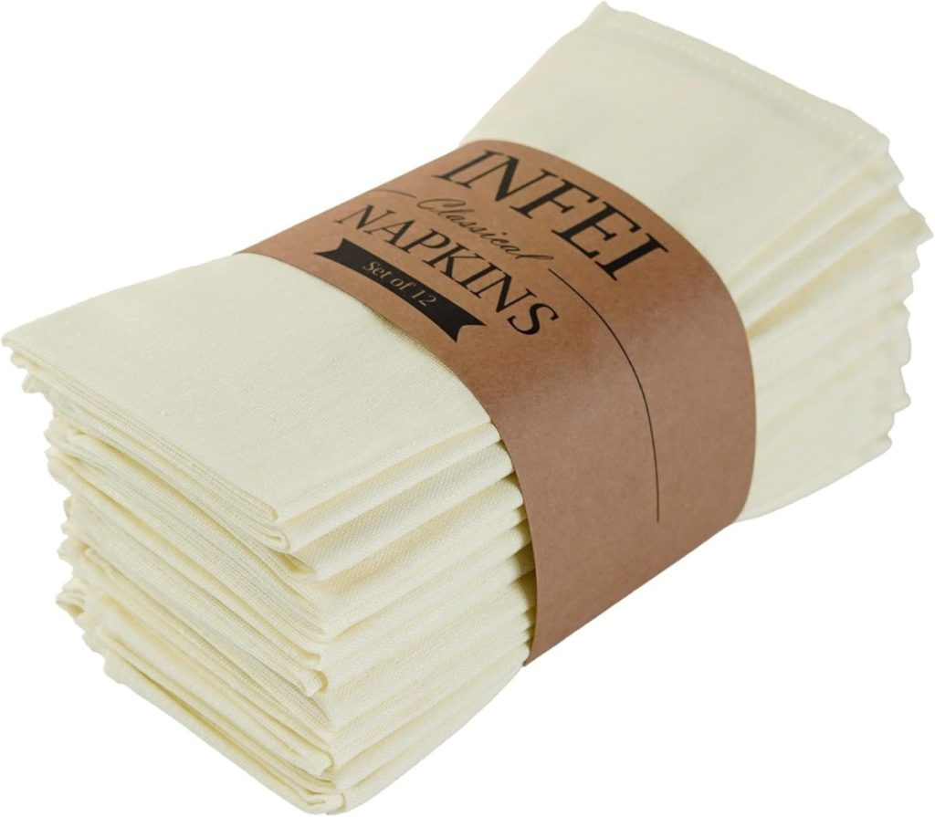 A stack of cream-colored cloth napkins is wrapped with a brown paper band labeled "YNFEI Cuisine Napkins Soft 12," perfect for Creative Crafts or elegant table settings.